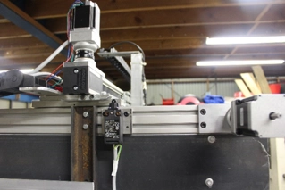 A stepper motor mounted on a linear guide rail for motion control in an industrial setup.