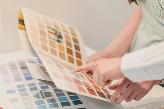 Close-up of two people reviewing a color palette for metal roofing and cladding, discussing bold and subtle design options.