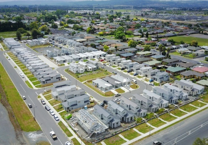 Aerial view of a large residential development with modern houses featuring grey steel TRS 6 roofing profiles.