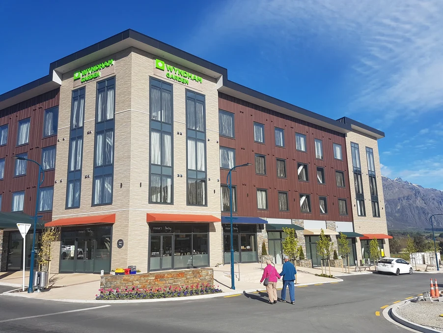 A hotel complex with a mix of natural wood, steel cladding, and brick finishes.