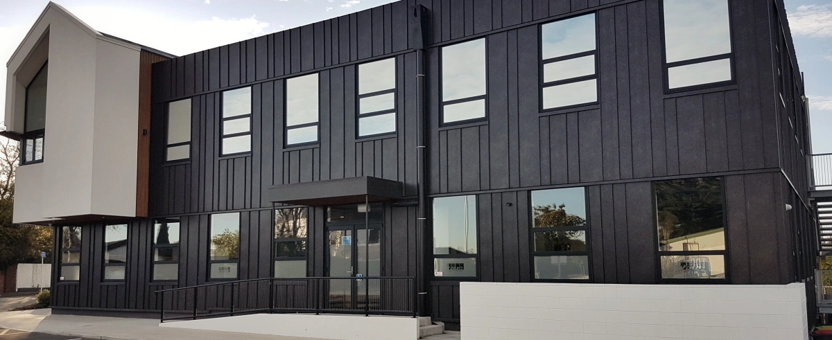 A modern commercial building featuring TRS Standing Seam cladding in a dark finish.