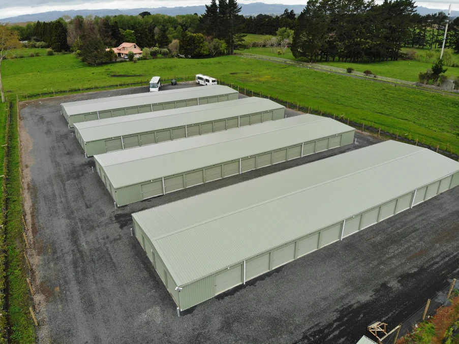 Storage units with grey steel roofing and cladding in a rural setting.