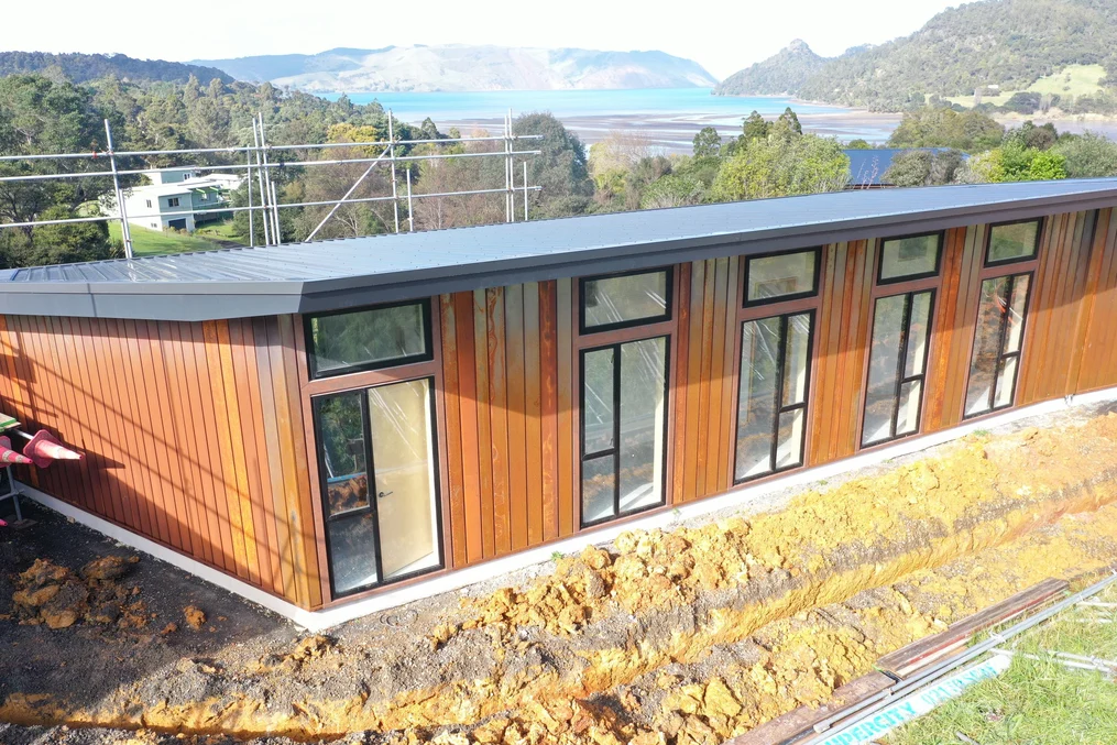 A commercial-style building with light wood-toned steel cladding and a modern flat roof design.