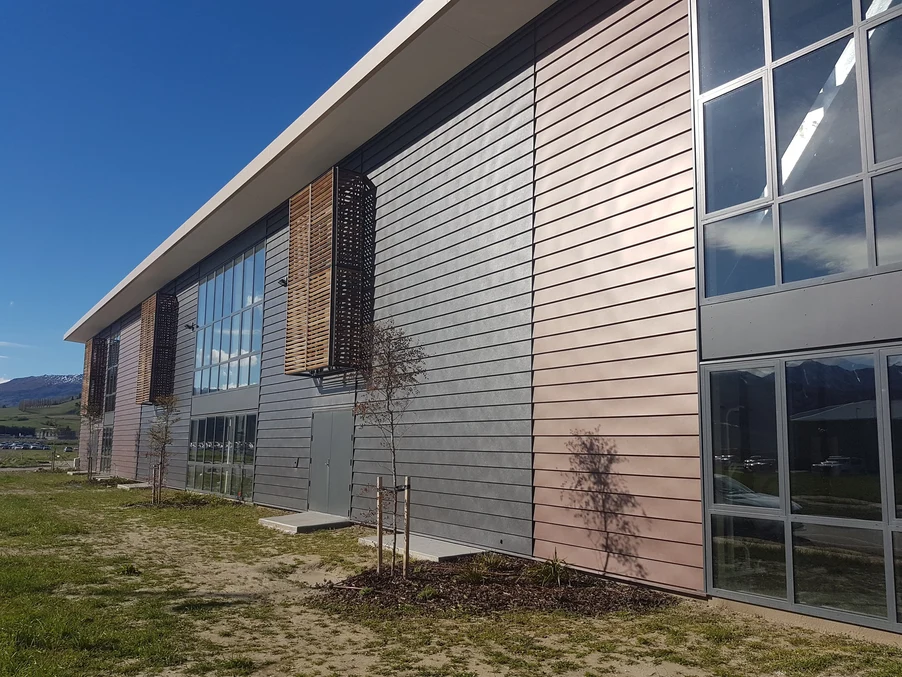 A commercial building with multi-coloured steel cladding and large glass windows.